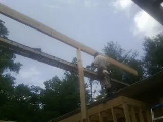 Carpenter setting a ridge beam over a new addition frame — Ice Dam Removal by Roofing Brothers in Frazeysburg