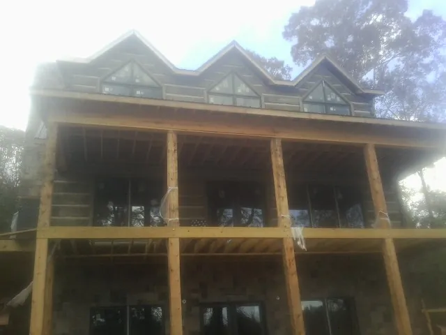 Dormers and porch framing on a large log home under construction — Roof Coating work by our crew in Frazeysburg