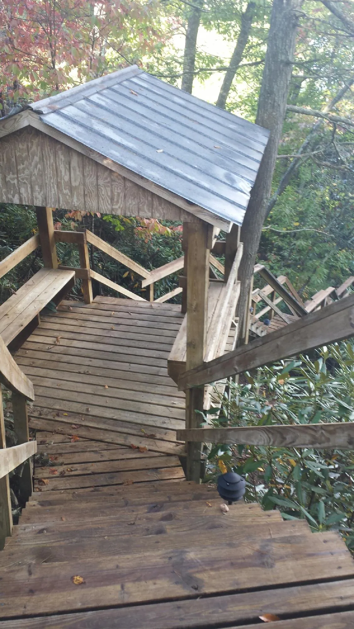 Metal roofed shelter over wooden steps on a wooded walkway — Skylight Repair & Installation work by our crew in Frazeysburg